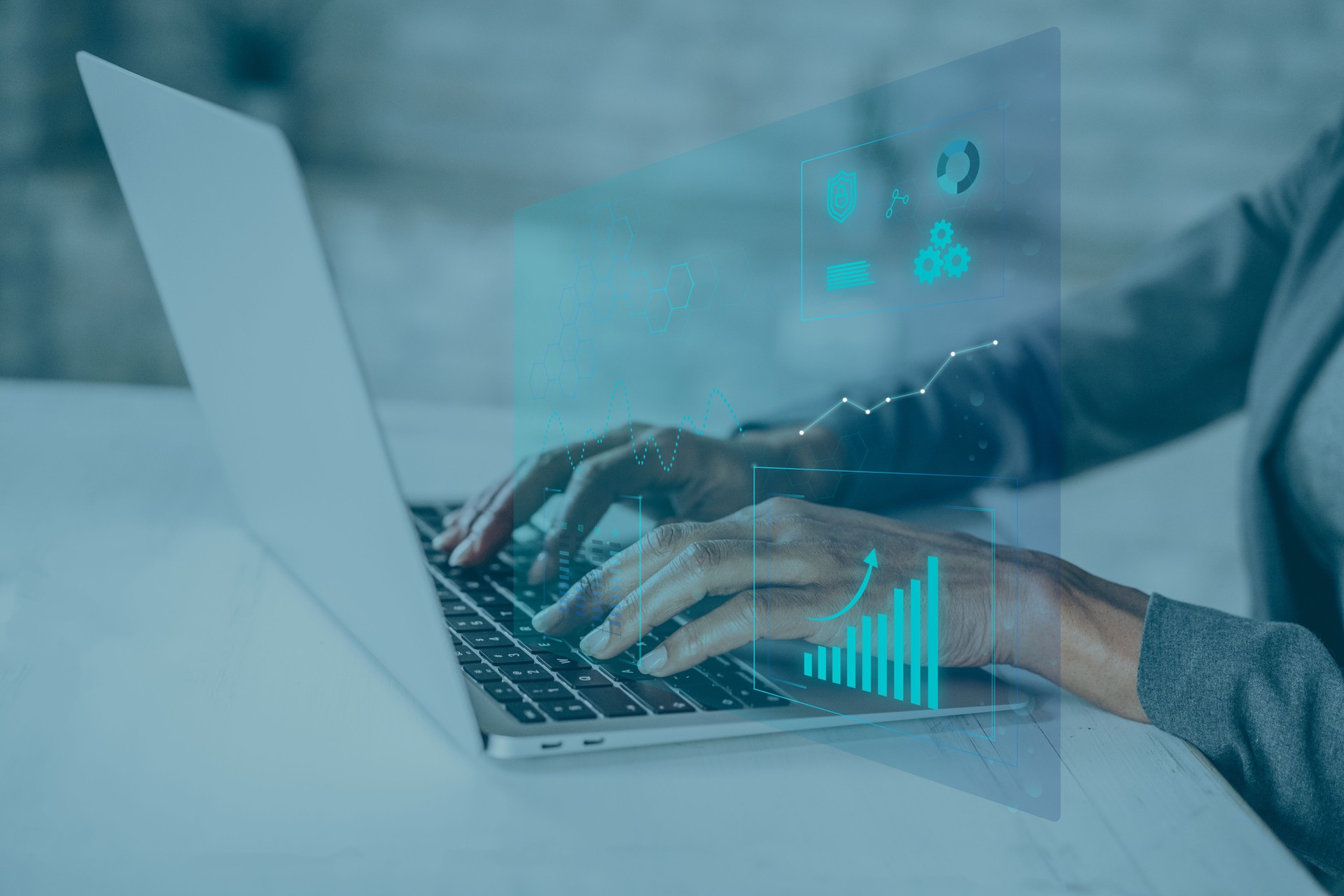 Businesswoman working on laptop with digital graphics and diagrams overlay.