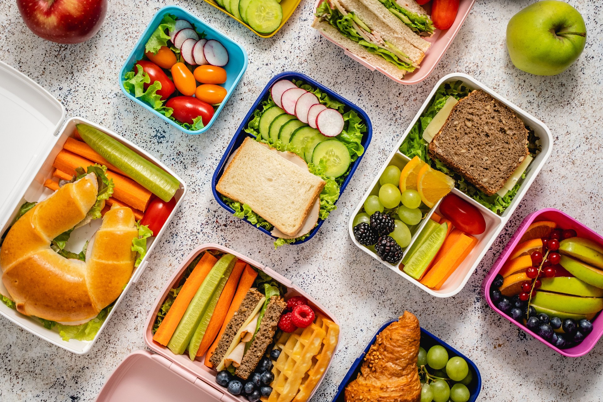 Shot of school lunchboxes with various healthy nutritious meals on stone background